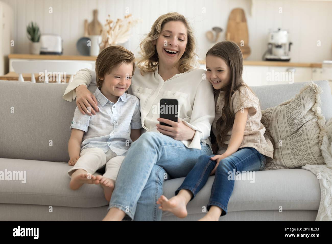 Cheerful mom and kids enjoy new application using smart phone Stock ...