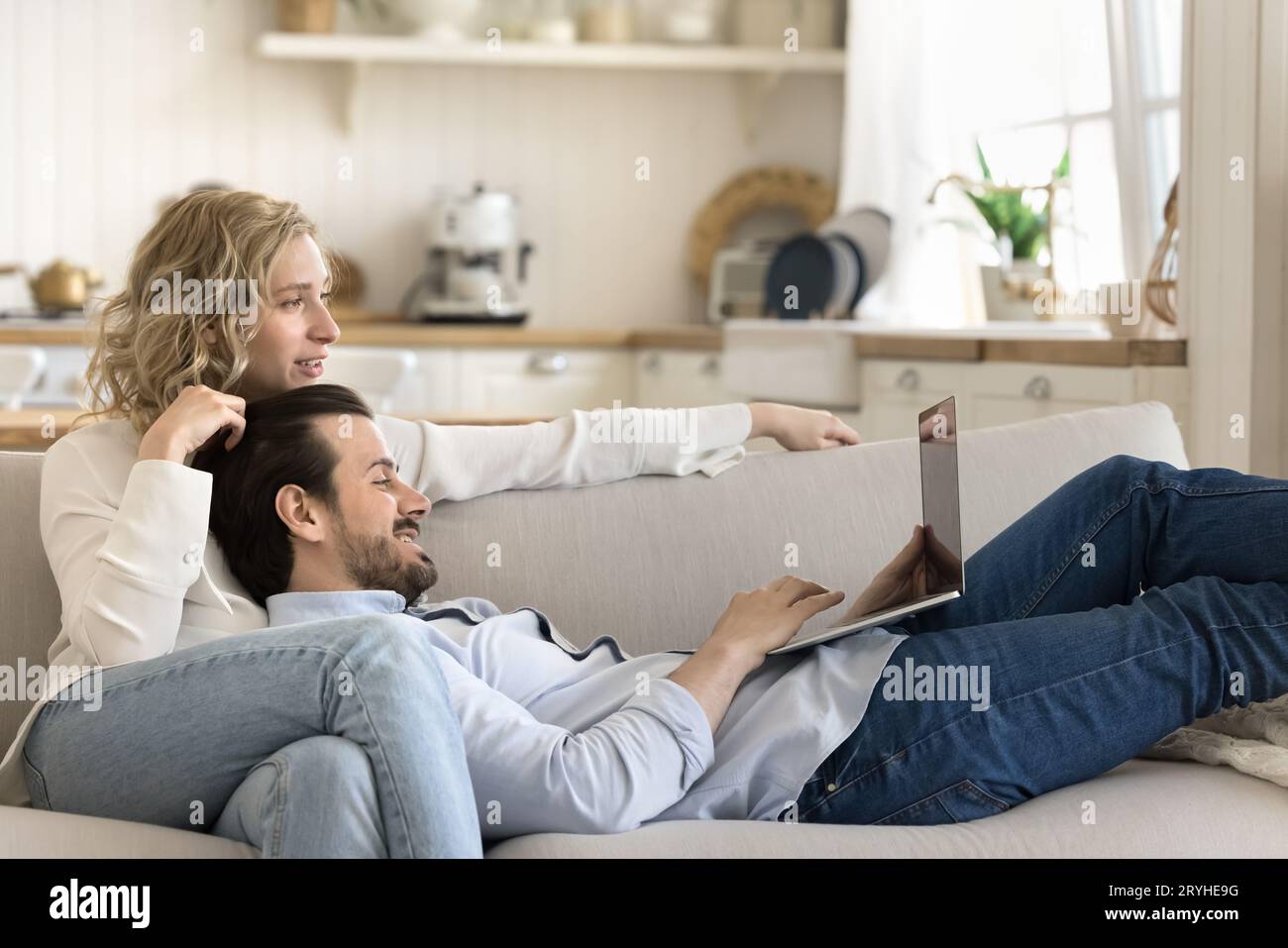 Couple spend time on internet resting on sofa using laptop Stock Photo