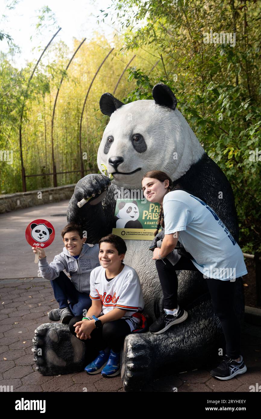 (231001) -- WASHINGTON, Oct. 1, 2023 (Xinhua) -- Visitors pose for photos with a giant panda statue at the Smithsonian's National Zoo in Washington, DC, the United States, Sept. 30, 2023. Giant pandas Mei Xiang, Tian Tian and Xiao Qi Ji, who are currently staying at the Smithsonian's National Zoo, will be returned home by the end of the year in accordance with a previous agreement with the China Wildlife Conservation Association (CWCA). To celebrate the joy the pandas have brought to the American people and say goodbye to them, the zoo held a 'giant farewell' event during the week ending Stock Photo
