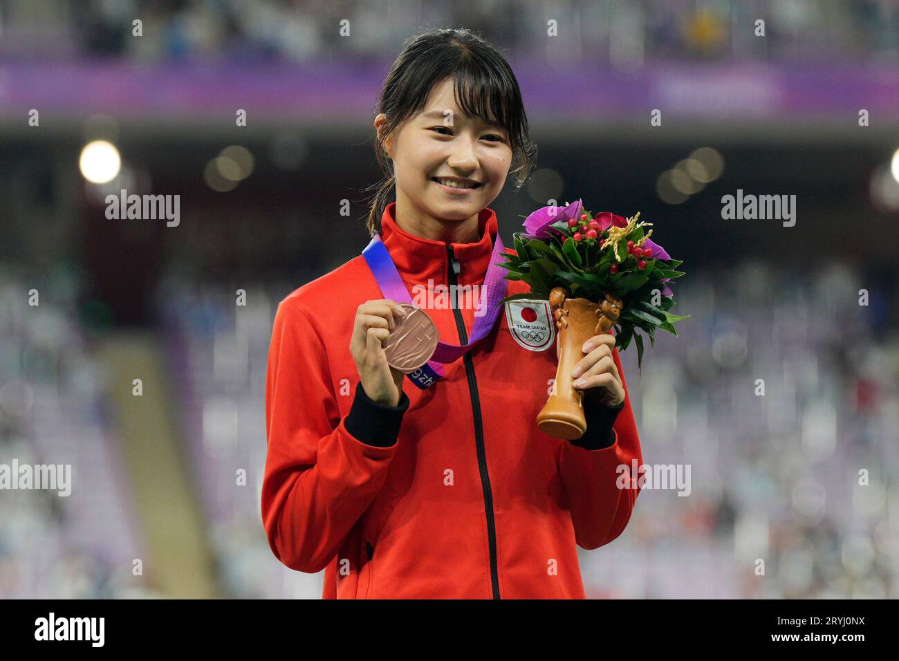 Bronze medalists Japan's Yumi Tanaka celebrates on the podium during the  victory ceremony for the women's 100-meter hurdles at the 19th Asian Games  in Hangzhou, China, Sunday, Oct. 1, 2023. (AP PhotoVincent