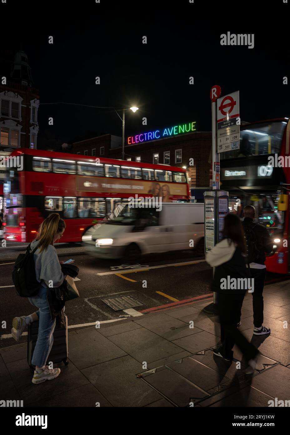 Brixton, London, UK: People waiting at a bus stop on Brixton Road ...