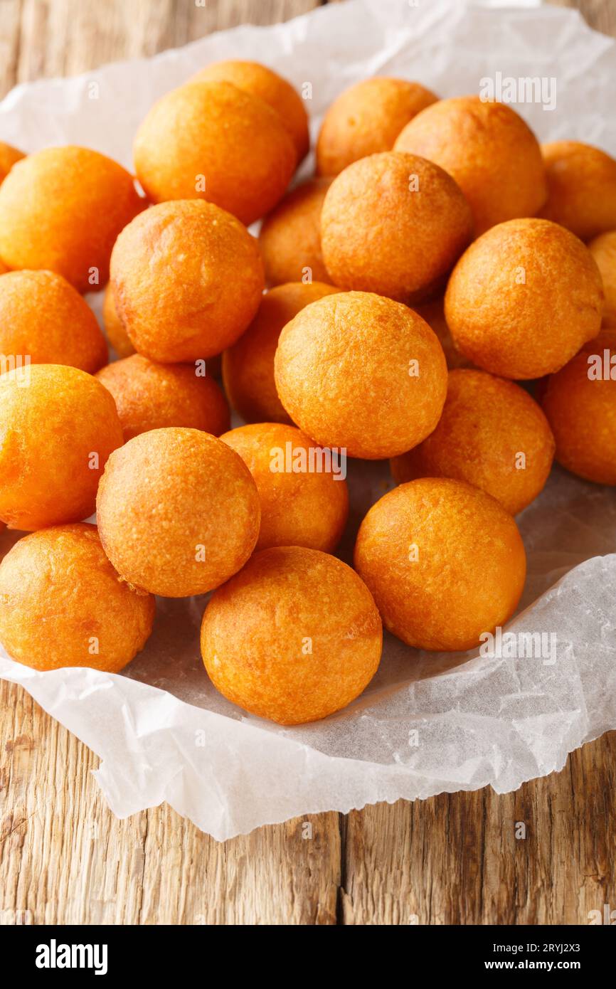 Khanom khai nok kratha Thai Deep Fried Sweet Potato Balls closeup on the wooden table. Vertical Stock Photo