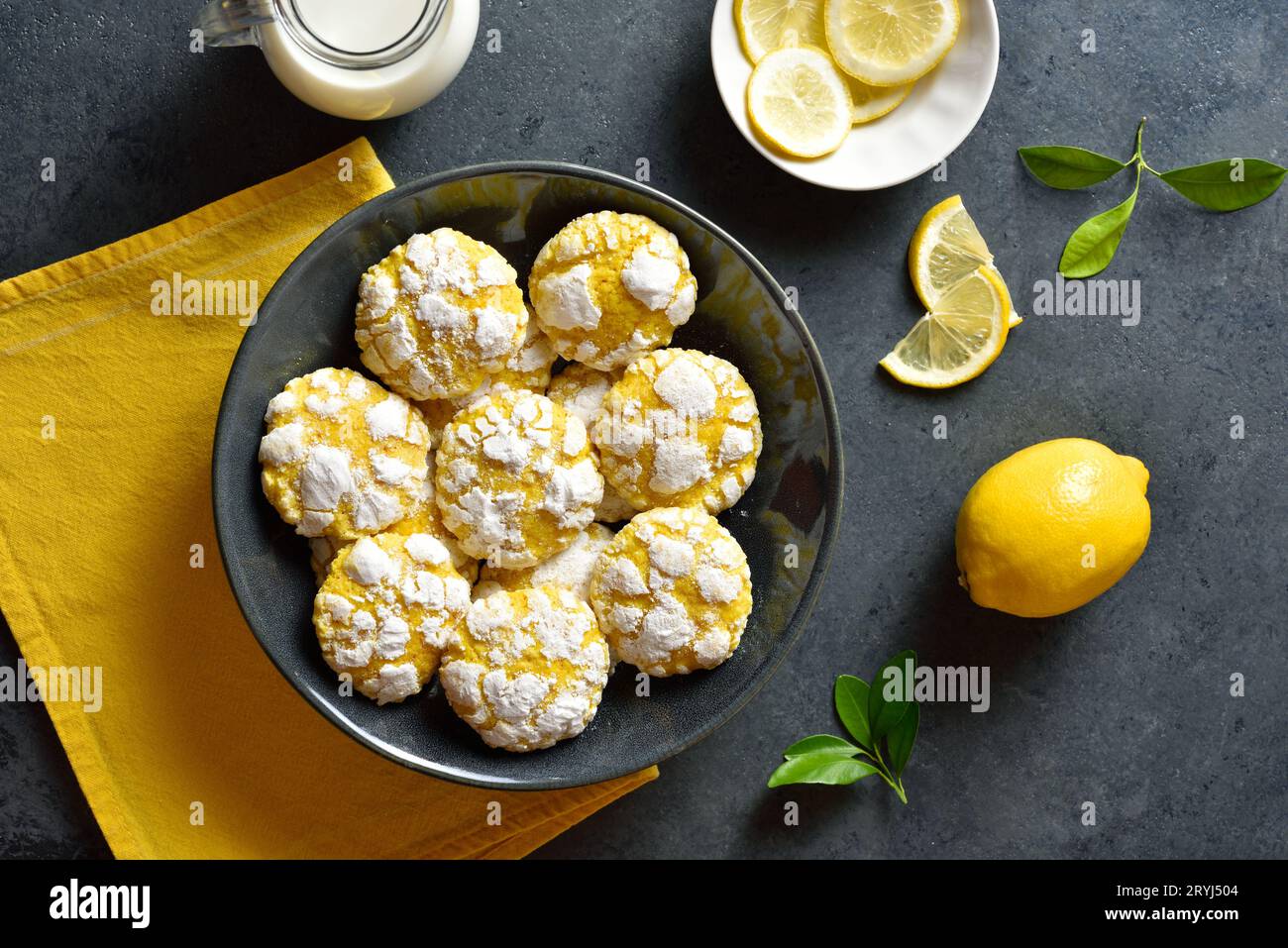Lemon crinkle cookies over dark stone background. Top view, flat lay Stock Photo