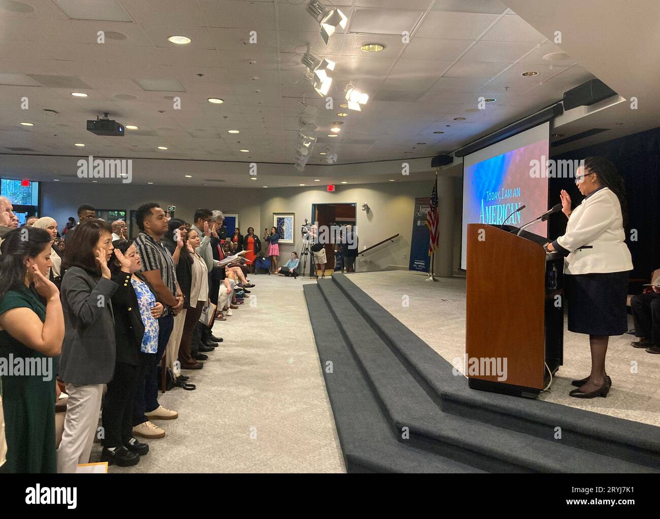 Denise Frazier, Atlanta district director for U.S. Citizenship and  Immigration Services, administers the oath of allegiance to 99 new American  citizens gathered at The Carter Center, Sunday, Oct. 1, 2023, in Atlanta,