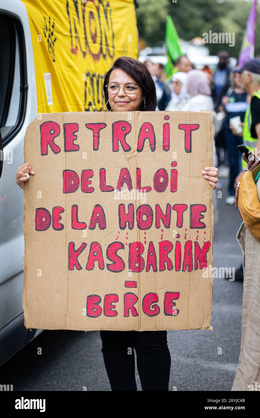 A protester holds a placard that says "Stop the shame law of Kasbarian