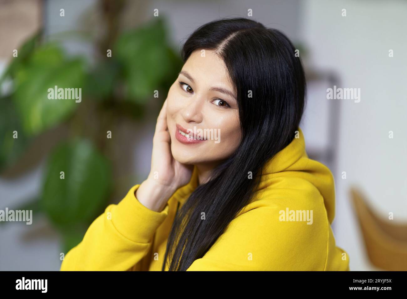 Pretty middle-aged Asian woman with healthy, glowing facial skin and well-groomed hair, promoting concept of healthy lifestyle. Stock Photo
