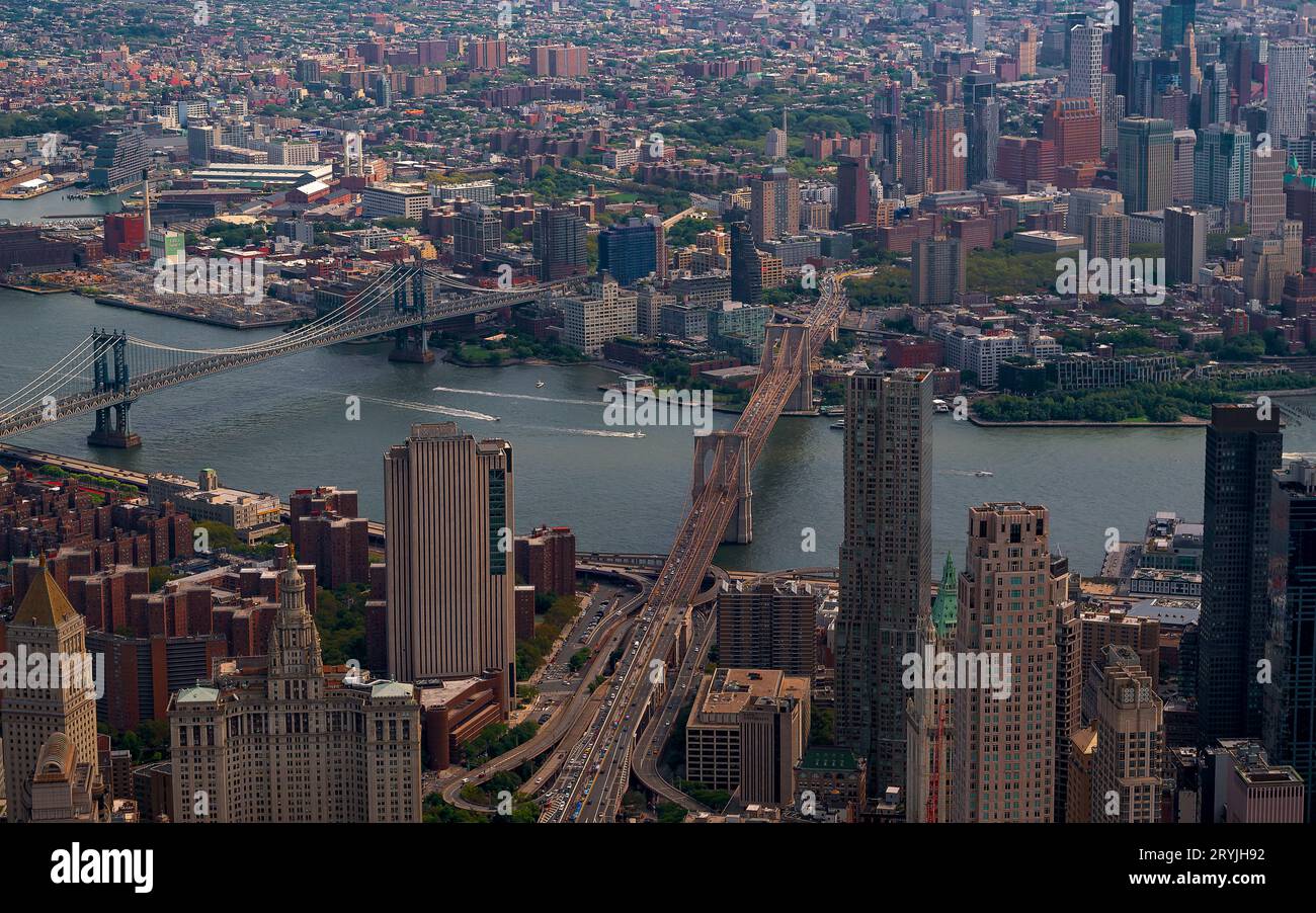 Aerial cityscape about New York city. The east river in the middle. Manhatttan and Brooklyn bridges are over the river. Brooklyn is on the background. Stock Photo
