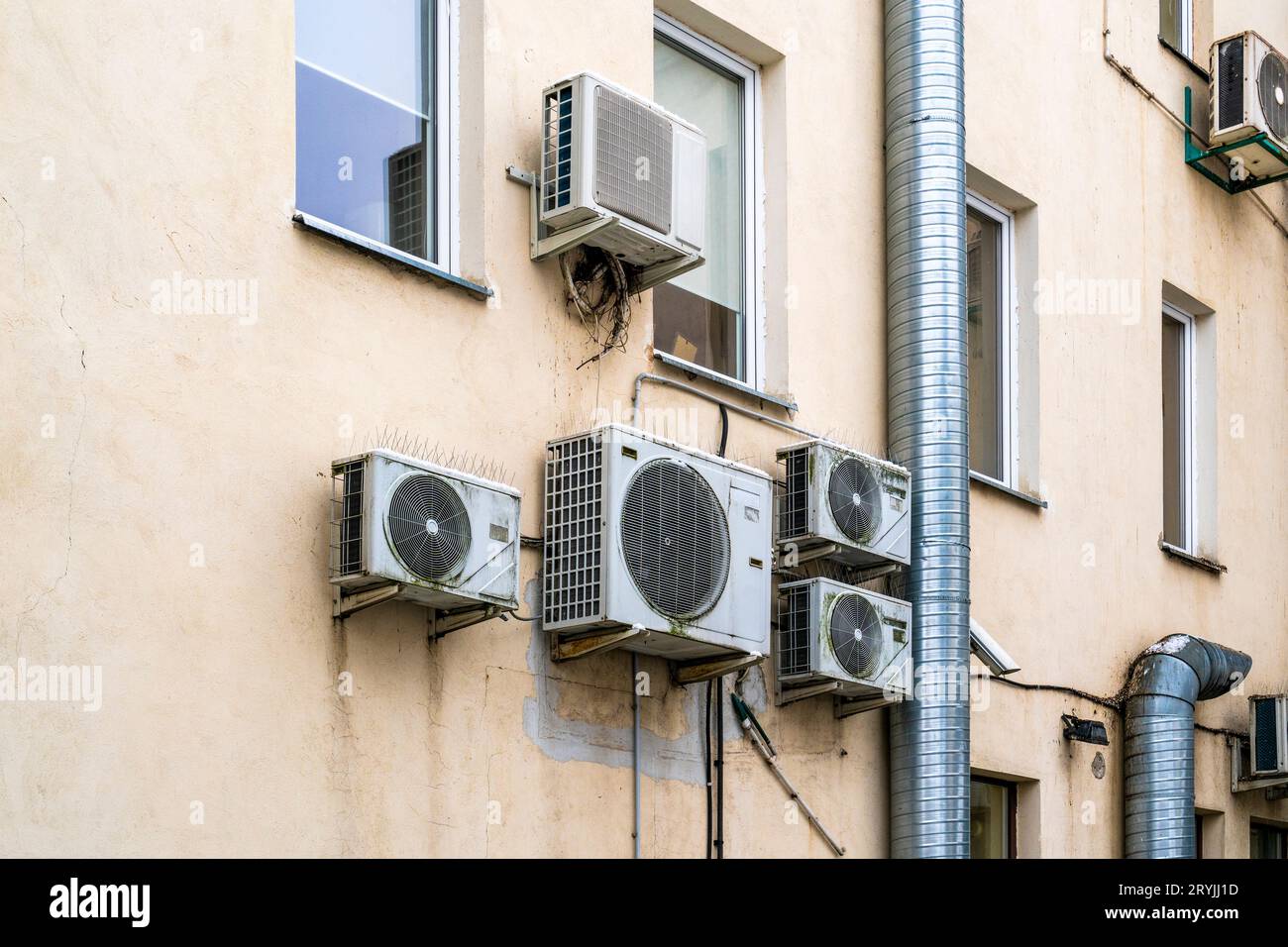 Old air-conditioners hangs on the facade of old building Stock Photo
