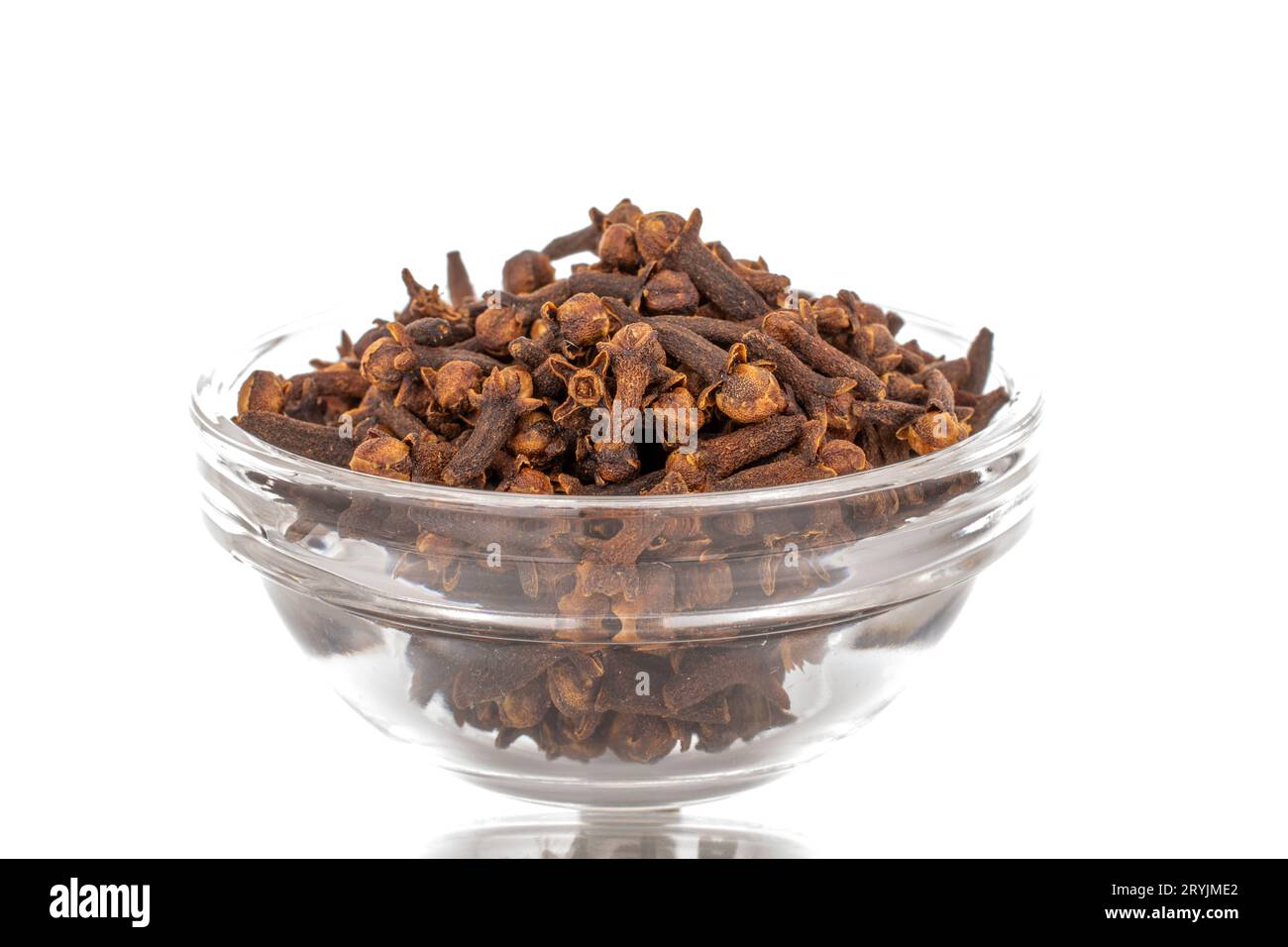 Dry aromatic cloves in a glass bowl, macro, isolated on white ...