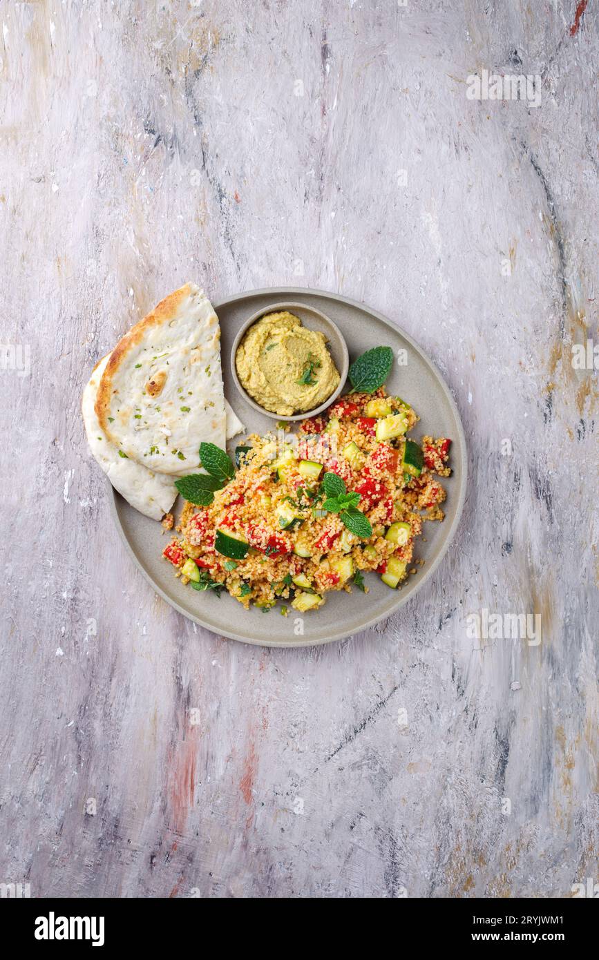Traditional Moroccan vegetable couscous with pita bread and hummus