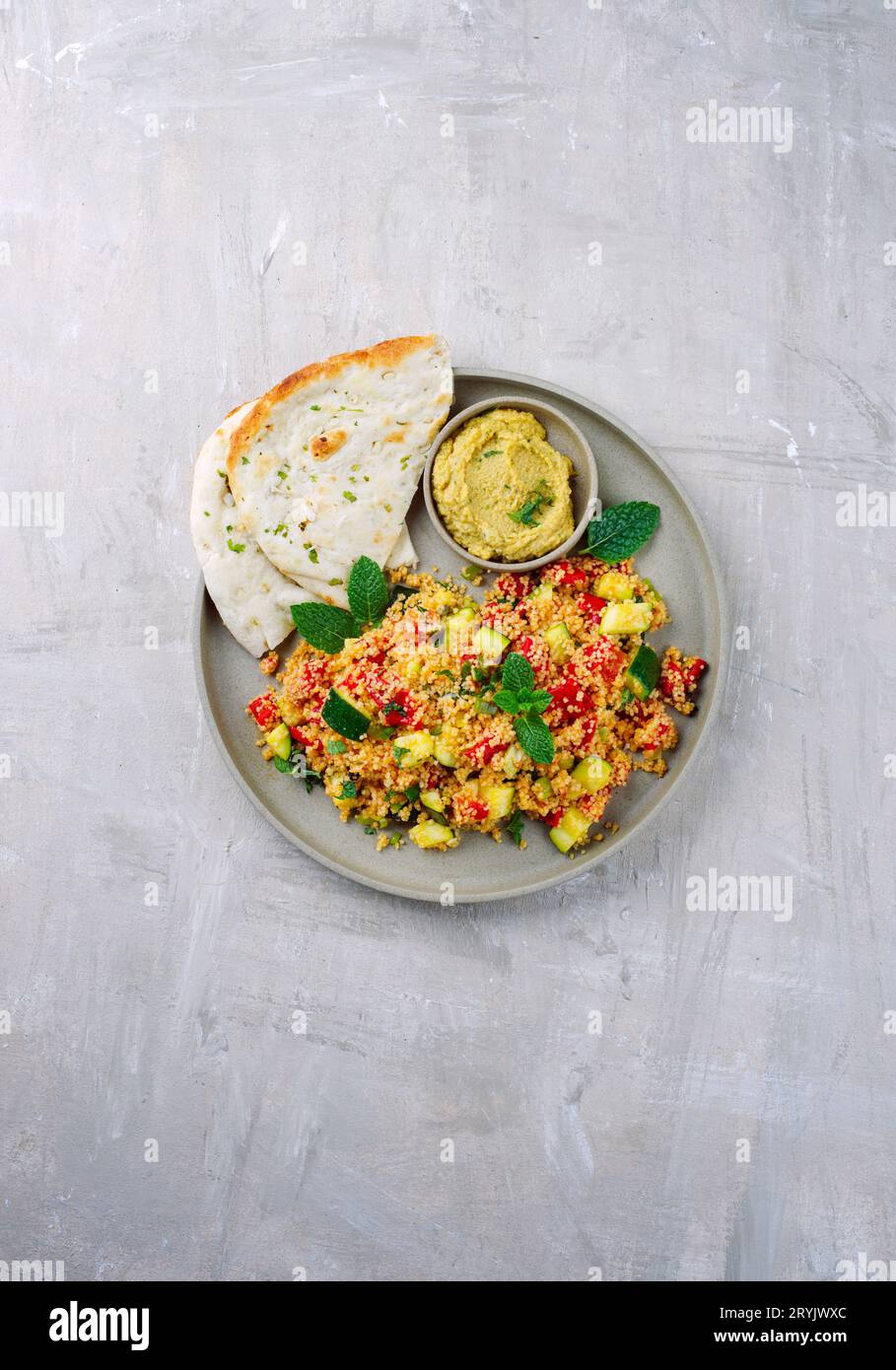Traditional Moroccan vegetable couscous with pita bread and hummus