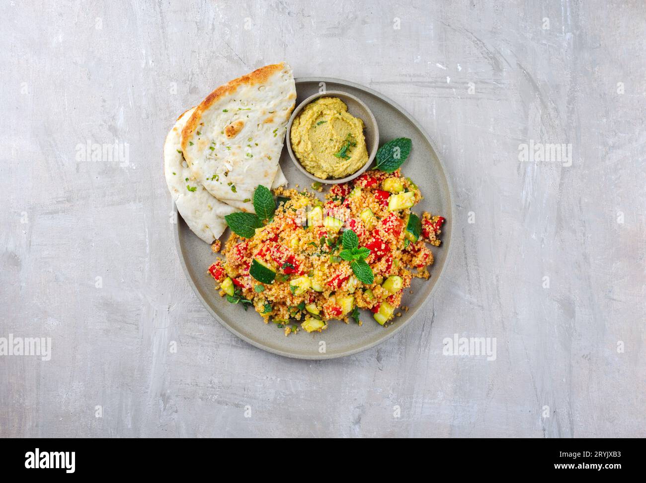 Traditional Moroccan vegetable couscous with pita bread and hummus