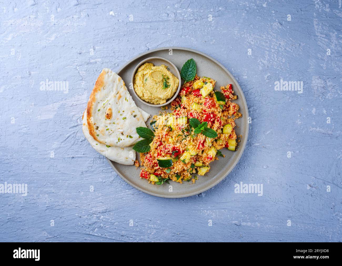 Traditional Moroccan vegetable couscous with pita bread and hummus