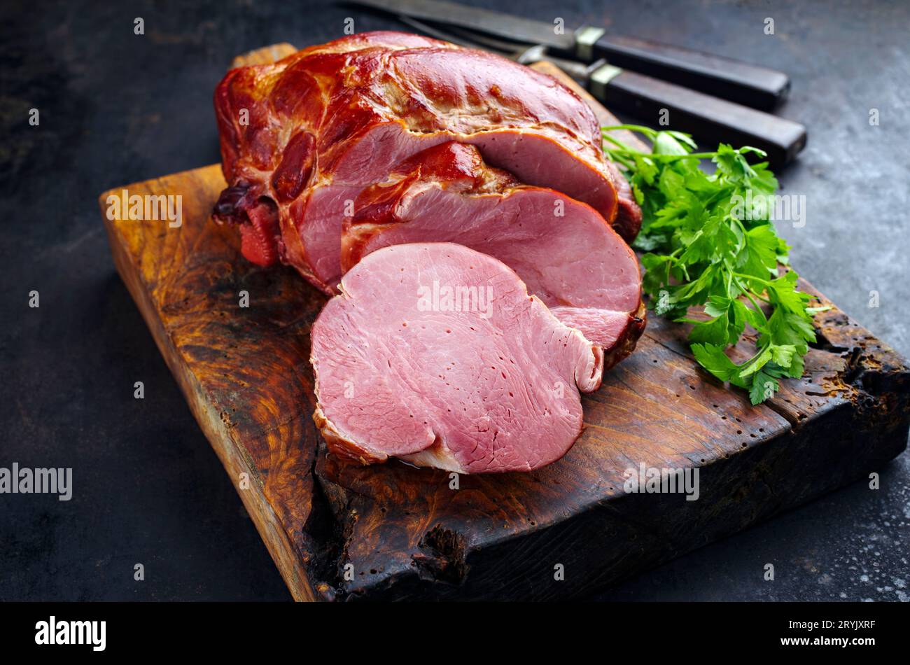 Traditional cured and smoked Baden schÃ¤ufele of pork shoulder served braised with parsley sliced as close-up on a rustic wooden Stock Photo