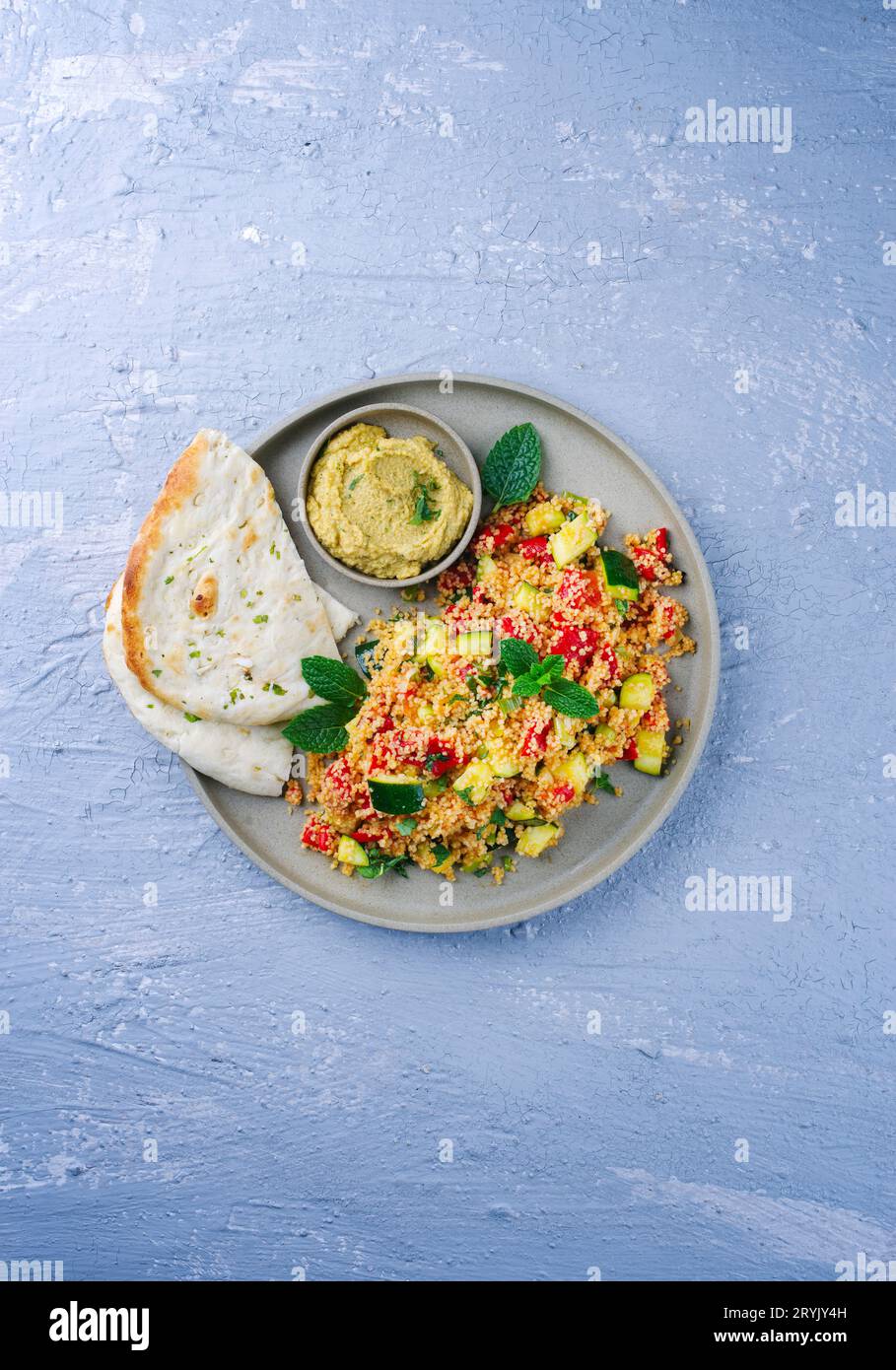 Traditional Moroccan vegetable couscous with pita bread and hummus