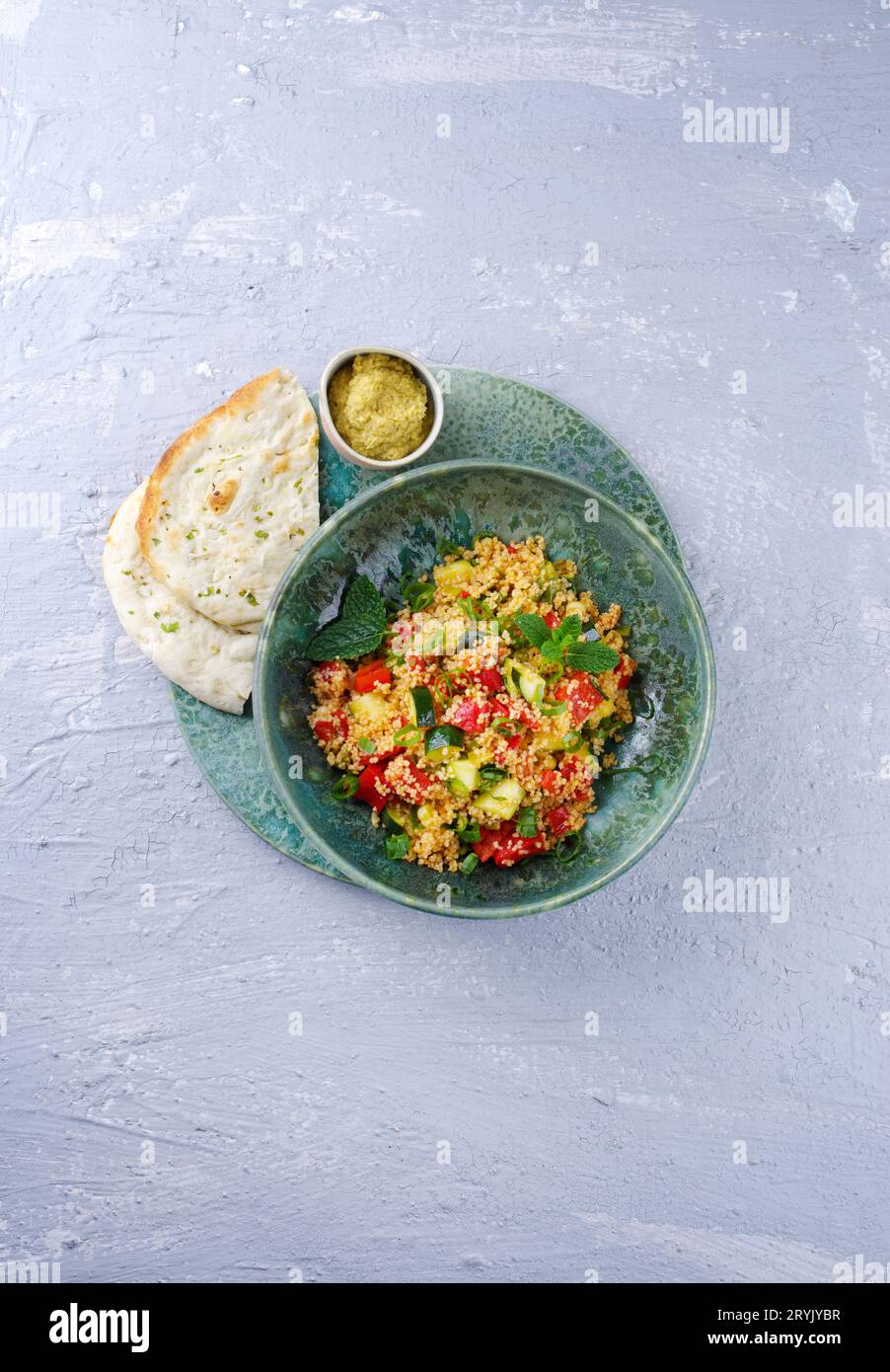Traditional Moroccan vegetable couscous with pita bread and hummus