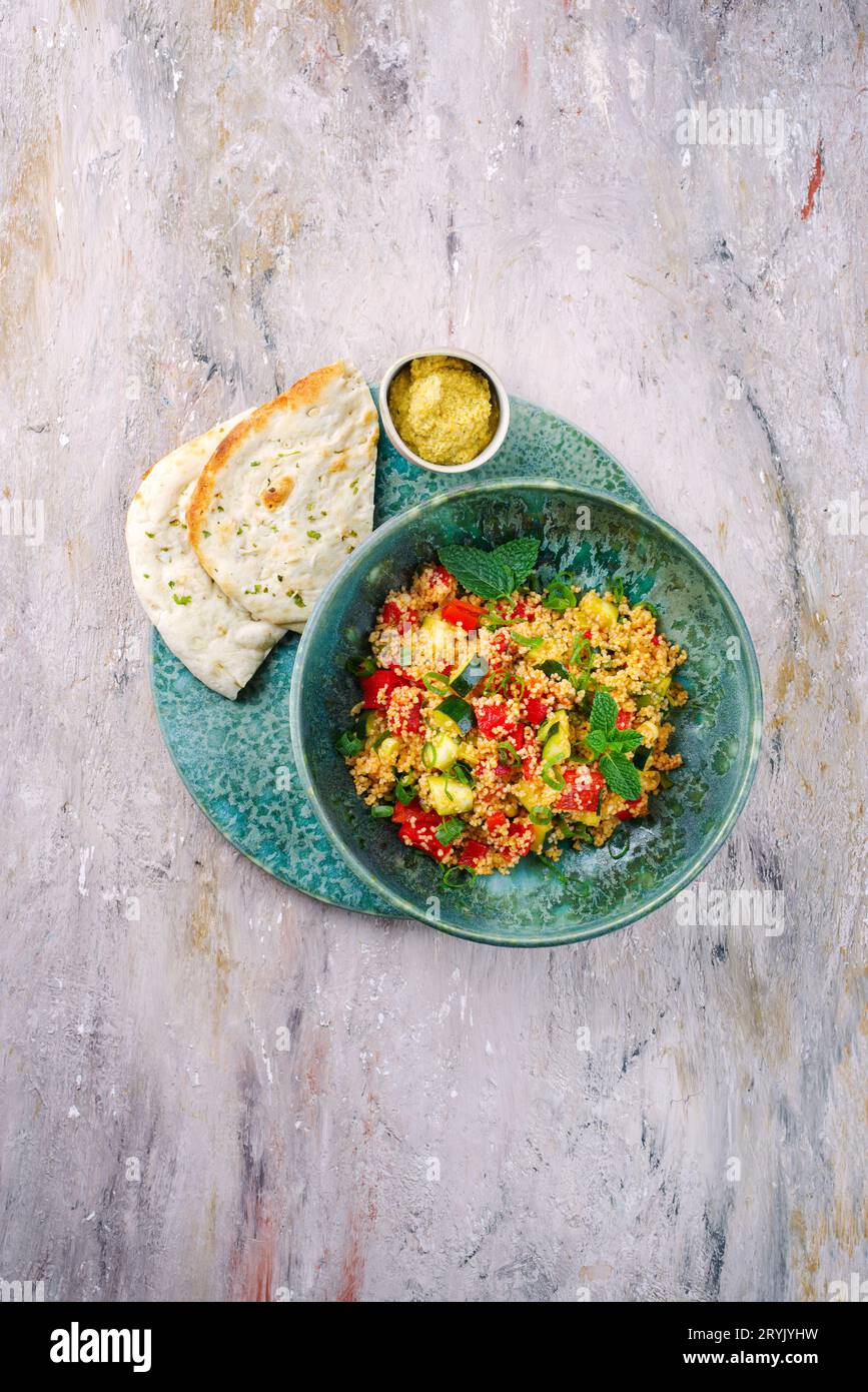 Traditional Moroccan vegetable couscous with pita bread and hummus