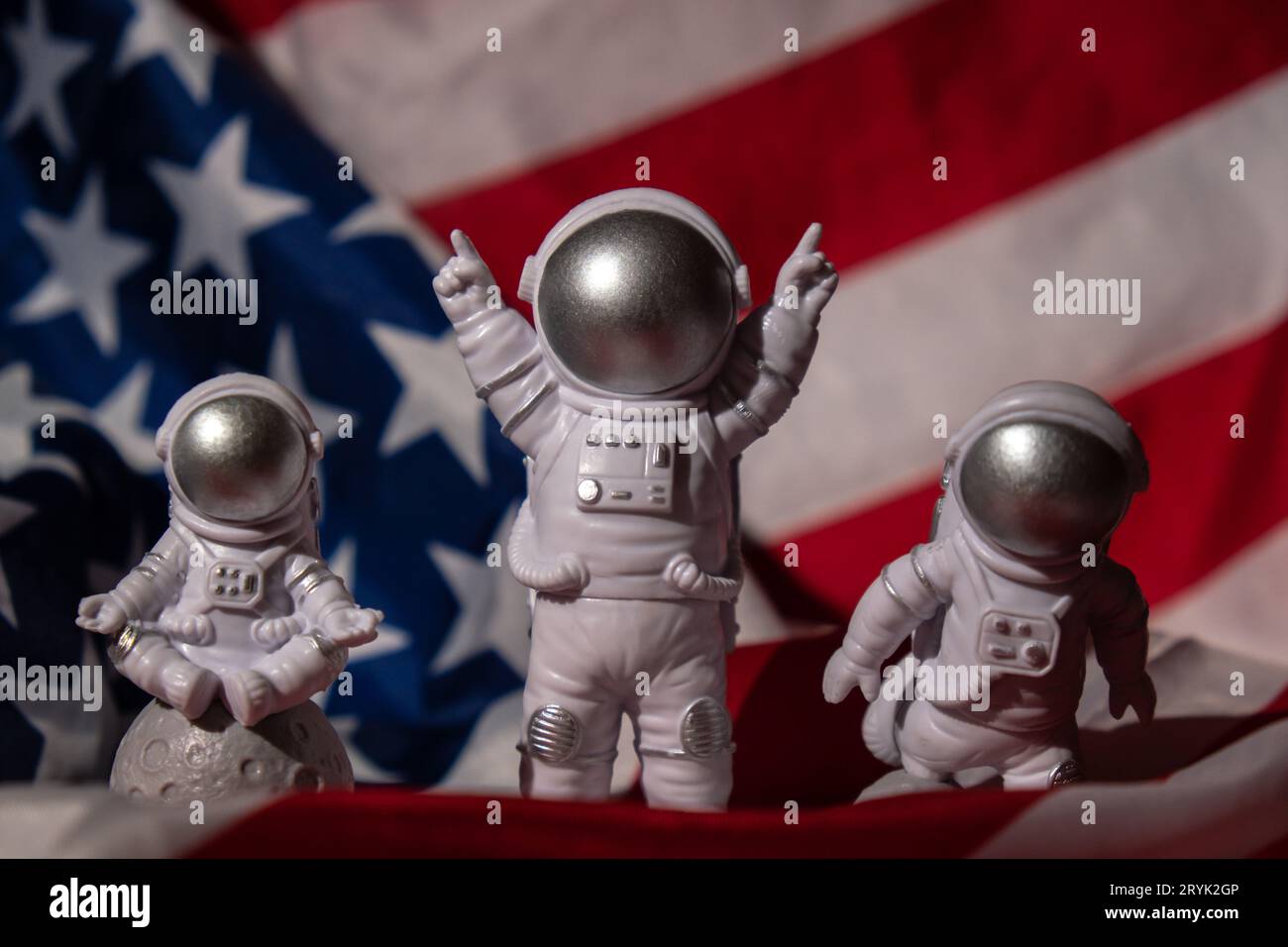 Three Plastic toys figure astronaut on American flag background Copy space. 50th Anniversary of USA Landing on The Moon Concept Stock Photo