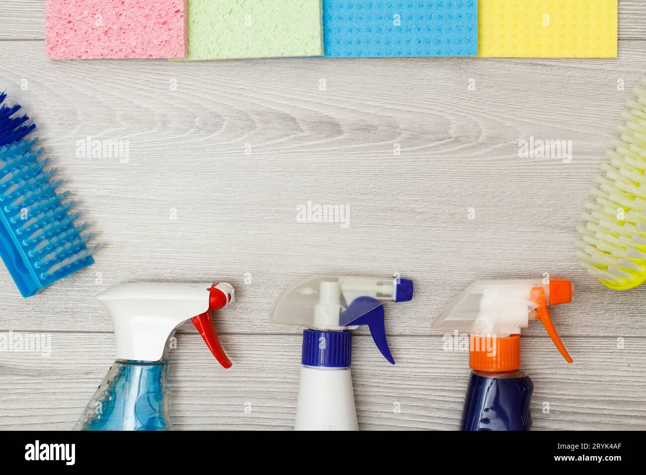 Bottles of detergent, color microfiber napkins and synthetic brushes for cleaning. Stock Photo