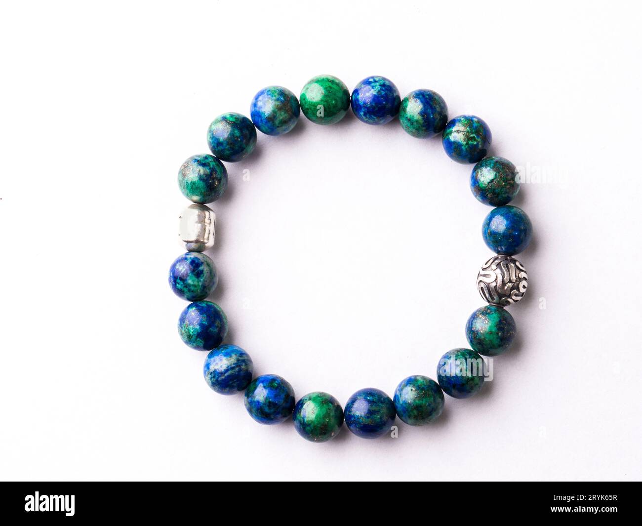 A blue and green beaded bracelet on a white surface Stock Photo