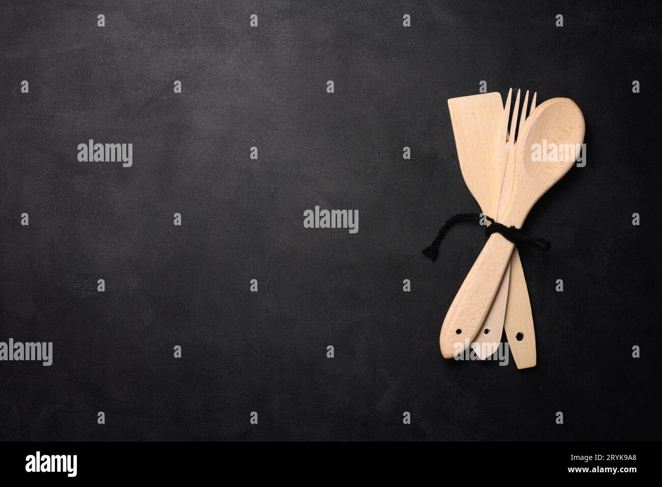 Fork and empty wooden spoon on a a black background, top view. Stock Photo