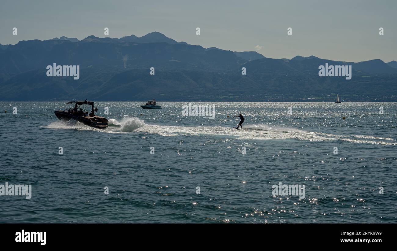 Ouchy, Lausanne, Vaud Canton, Switzerland - 24 September, 2023 : Motorboat with people wakeboarding in Lake Geneva. Stock Photo