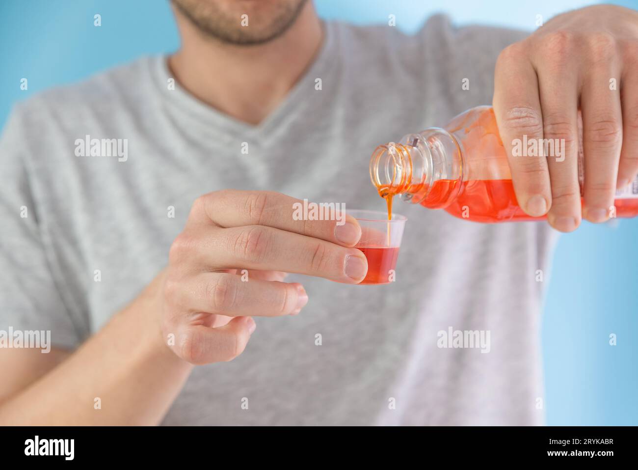 Man poring portion of liquid medicine syrup for treatment cold and flu