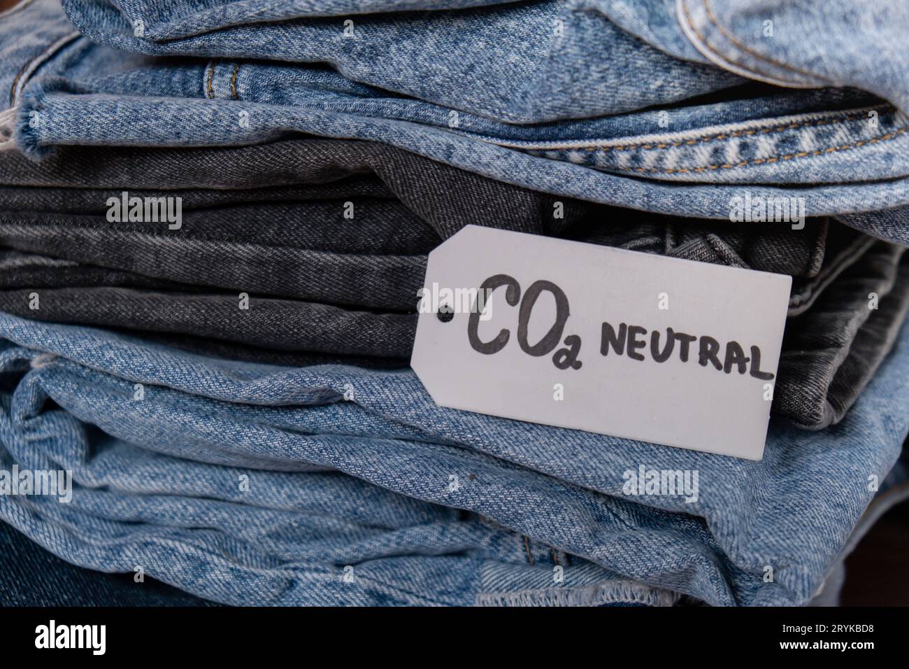 CO2 neutral emission text note on stack of jeans. Ecology nature friendly, climate change, green fuel and earth protect concept. Stock Photo