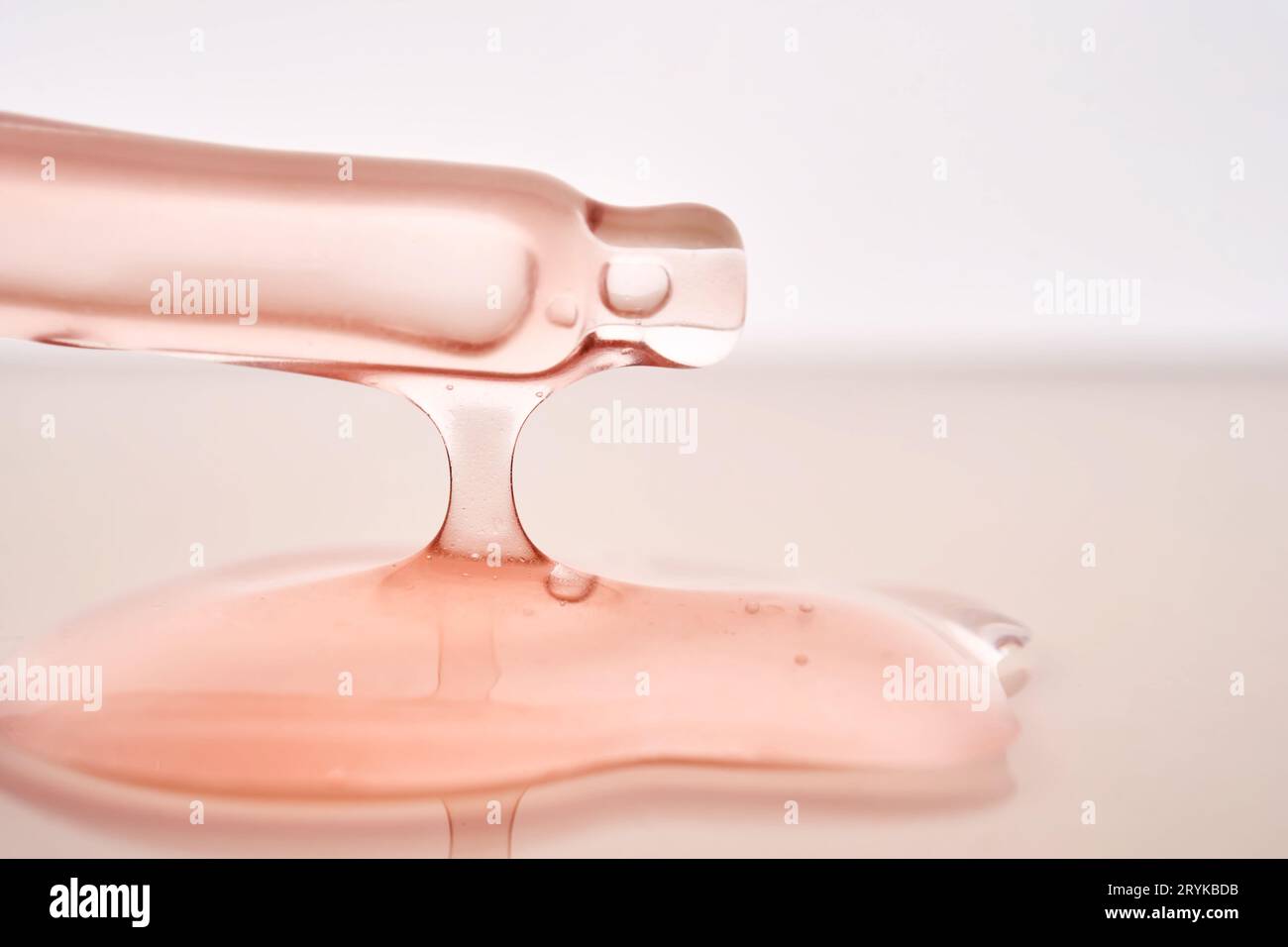 Pipette with a viscous pink cosmetic close-up. Stock Photo