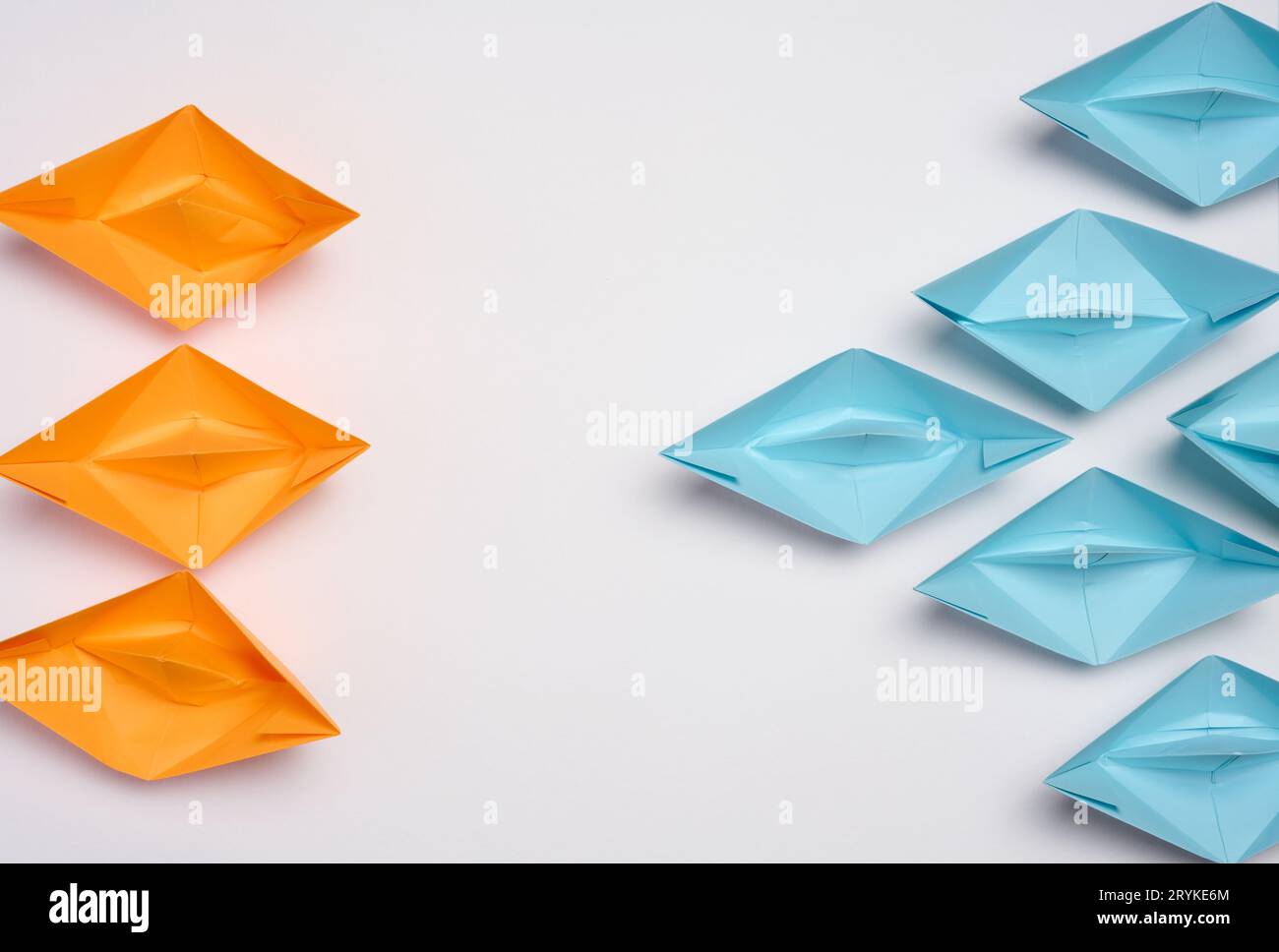 Two groups of paper boats facing each other, a concept of confrontation, top view Stock Photo