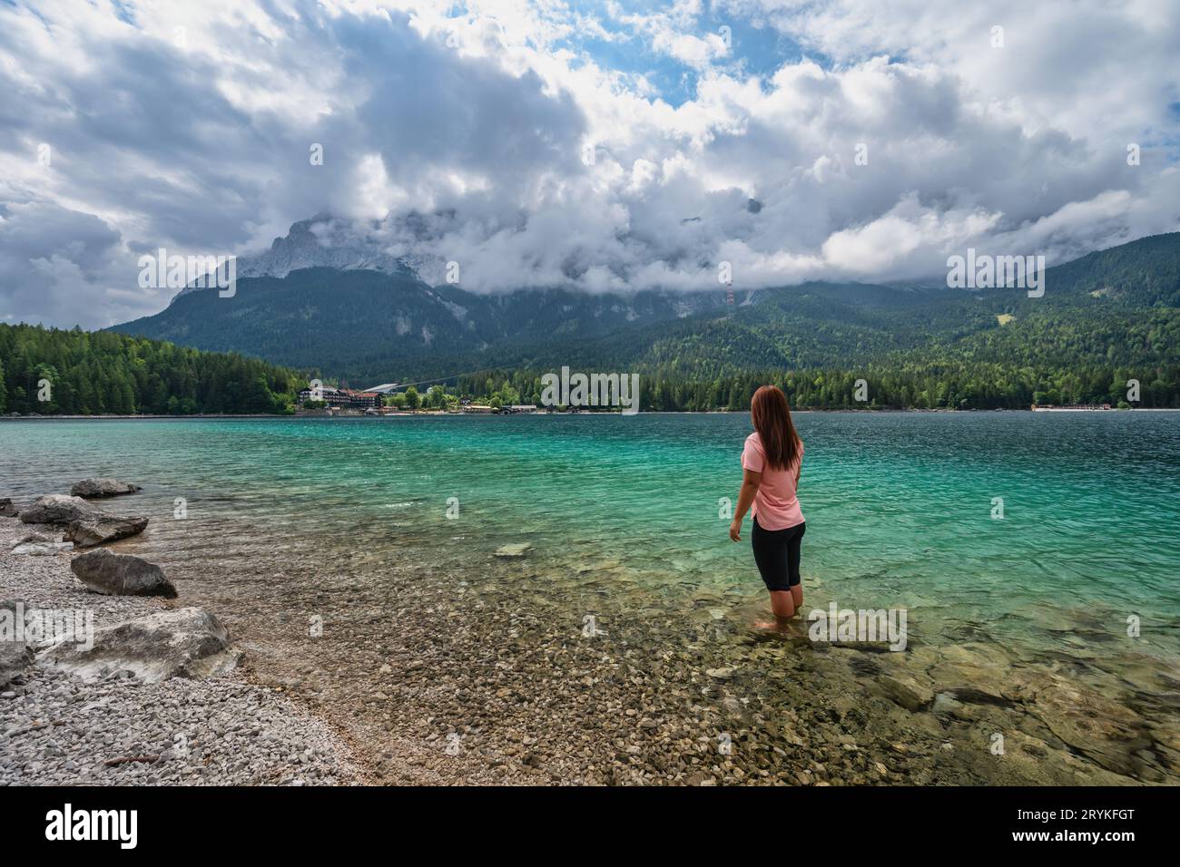 Zugspitze Peak top of Germany Alps mountain range and Eibsee Lake with woman tourist, Garmisch Parte Stock Photo