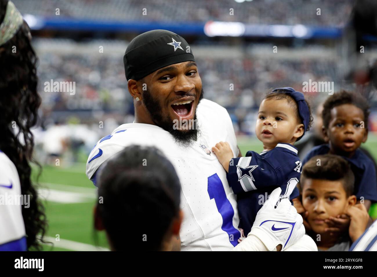 Dallas Cowboys' Micah Parsons smiles as he talks interacts with with family  on the sideline before the first half of an NFL football game against the  New England Patriots in Arlington, Texas,