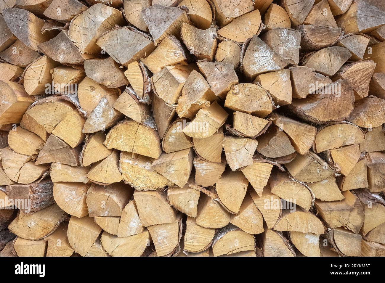 Chopped dry firewood stacked for fireplace, irregular rustic background. Stock Photo
