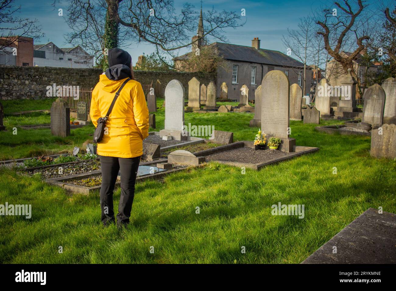 Unknown woman mourning in front of a tombstone in an english looking