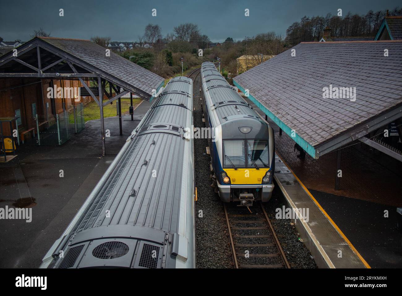 Two diesel trains are crossing at ballymoney train station in northern ireland. Looking towards the trains and train tracks from the pedestrian overpa Stock Photo