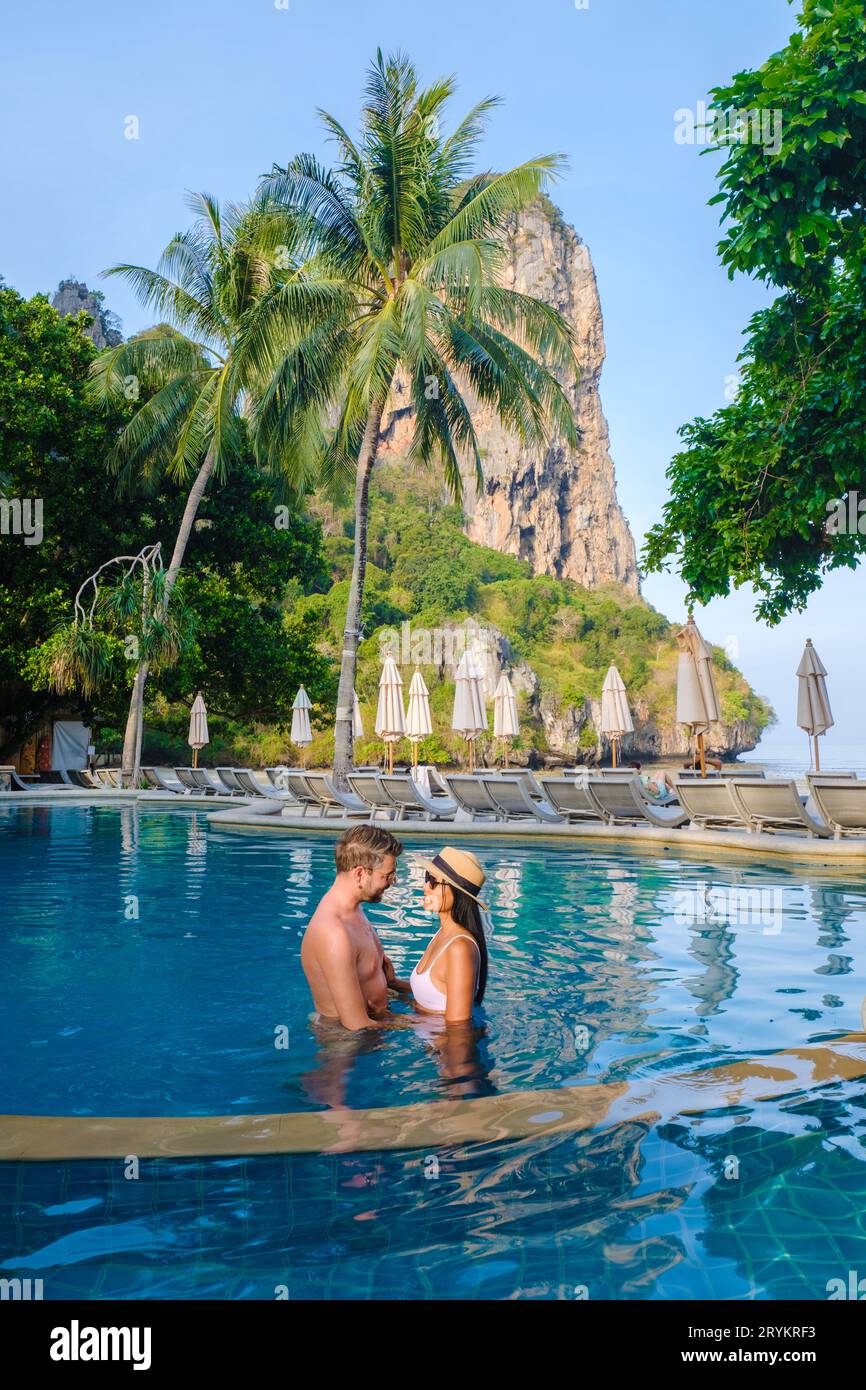 Couple of men and women at a swimming pool of a luxury resort in Thailand Stock Photo
