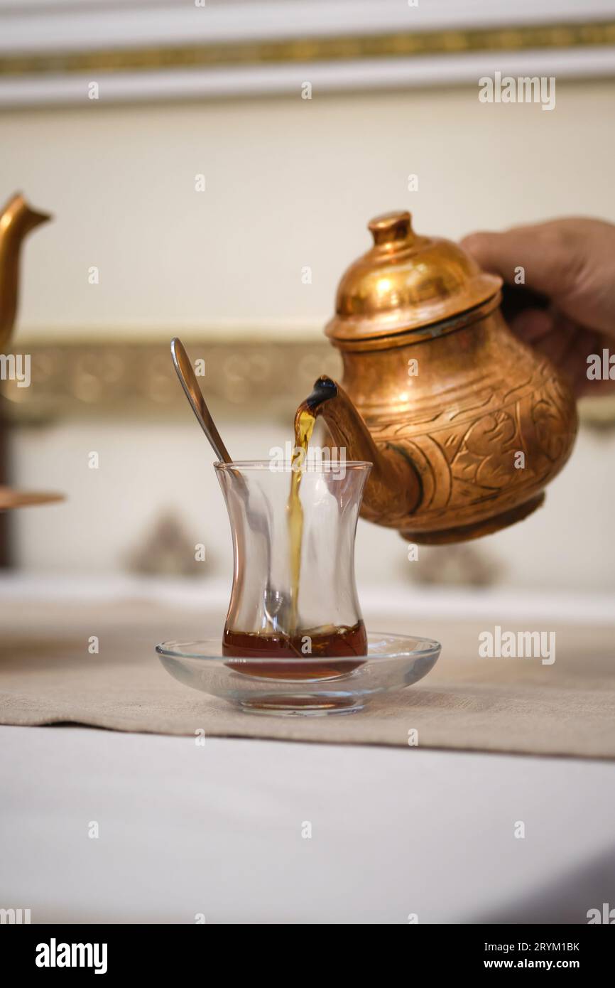 Hand Over Tea Hand pours tea from traditional hi-res stock photography and images - Alamy