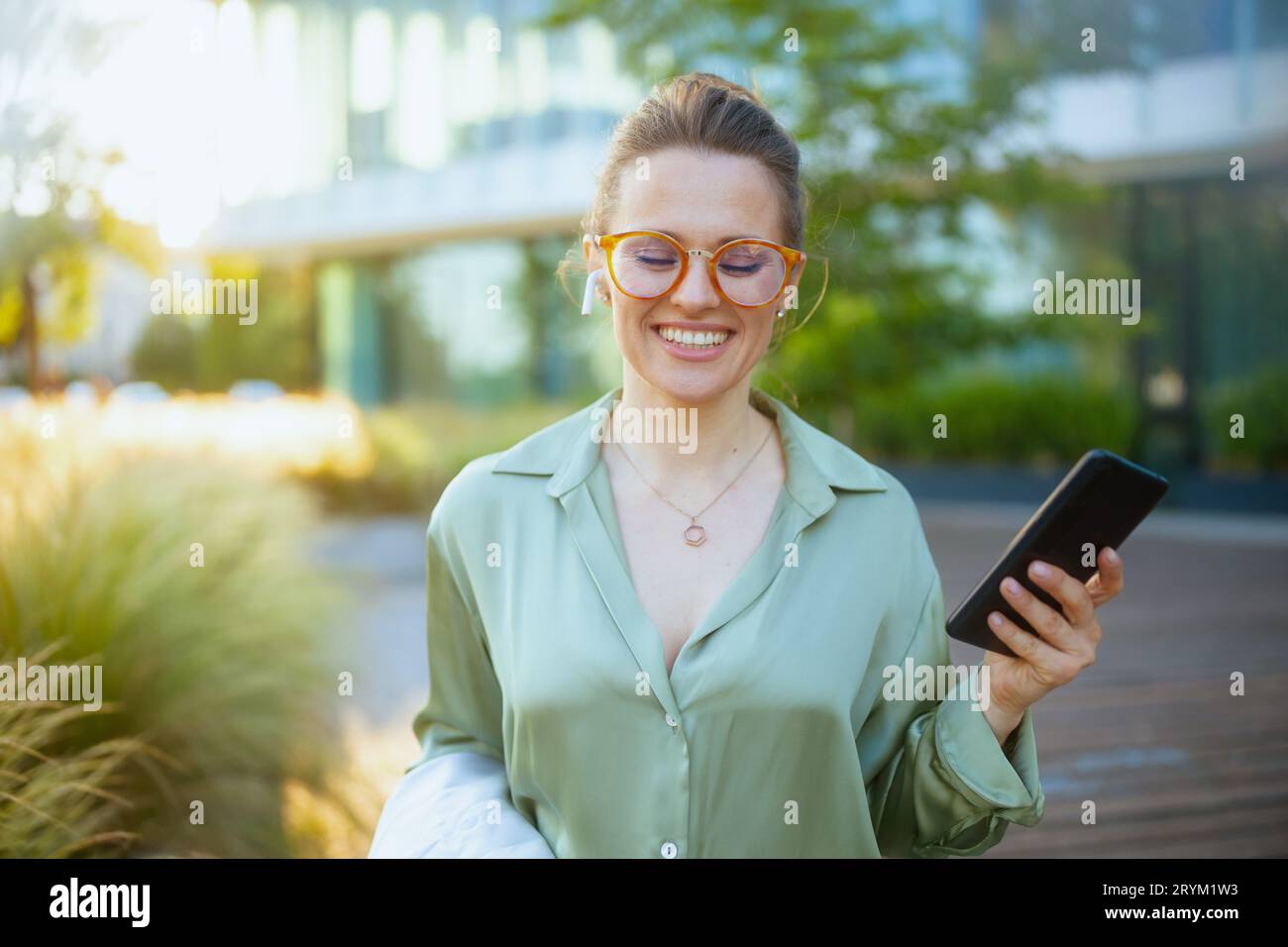 happy modern female employee near office building in green blouse and ...