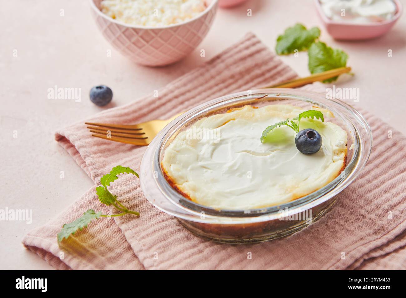 Delicious cottage cheese casserole in portioned glass forms with sour cream. Traditional Russian cuisine for breakfast - Zapekan Stock Photo