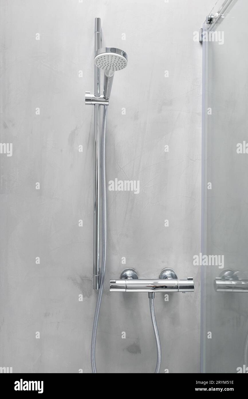 Shower head and temperature control on a grey microcement Stock Photo