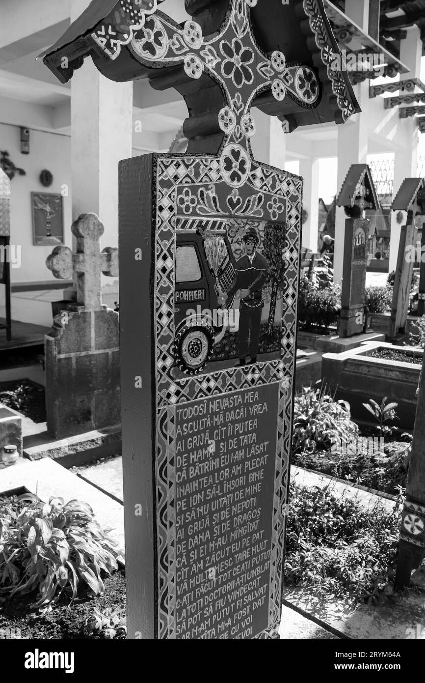 Black and white Merry Cemetery headstone graveyard with colorful naïve paintings describing the buried people. One of the Seven Wonders of Romania Stock Photo