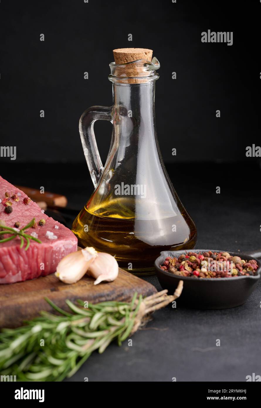 Glass bottle with olive oil on black table Stock Photo