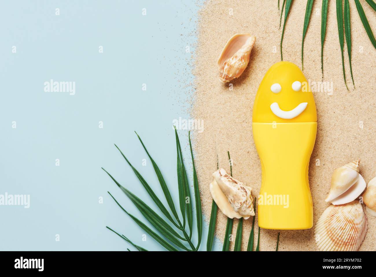 Sun protection cosmetics product concept. Yellow tube with face painted cream Stock Photo