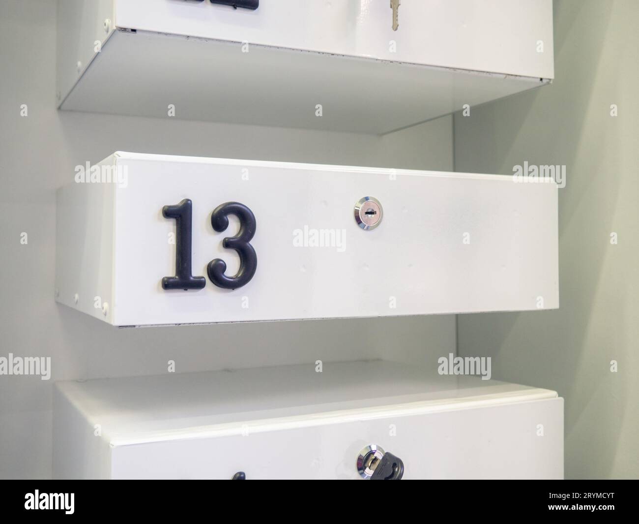 Boxes in the post office. Mini safe with key. The concept of secure storage. Box numbers 13. Personal mailbox Stock Photo