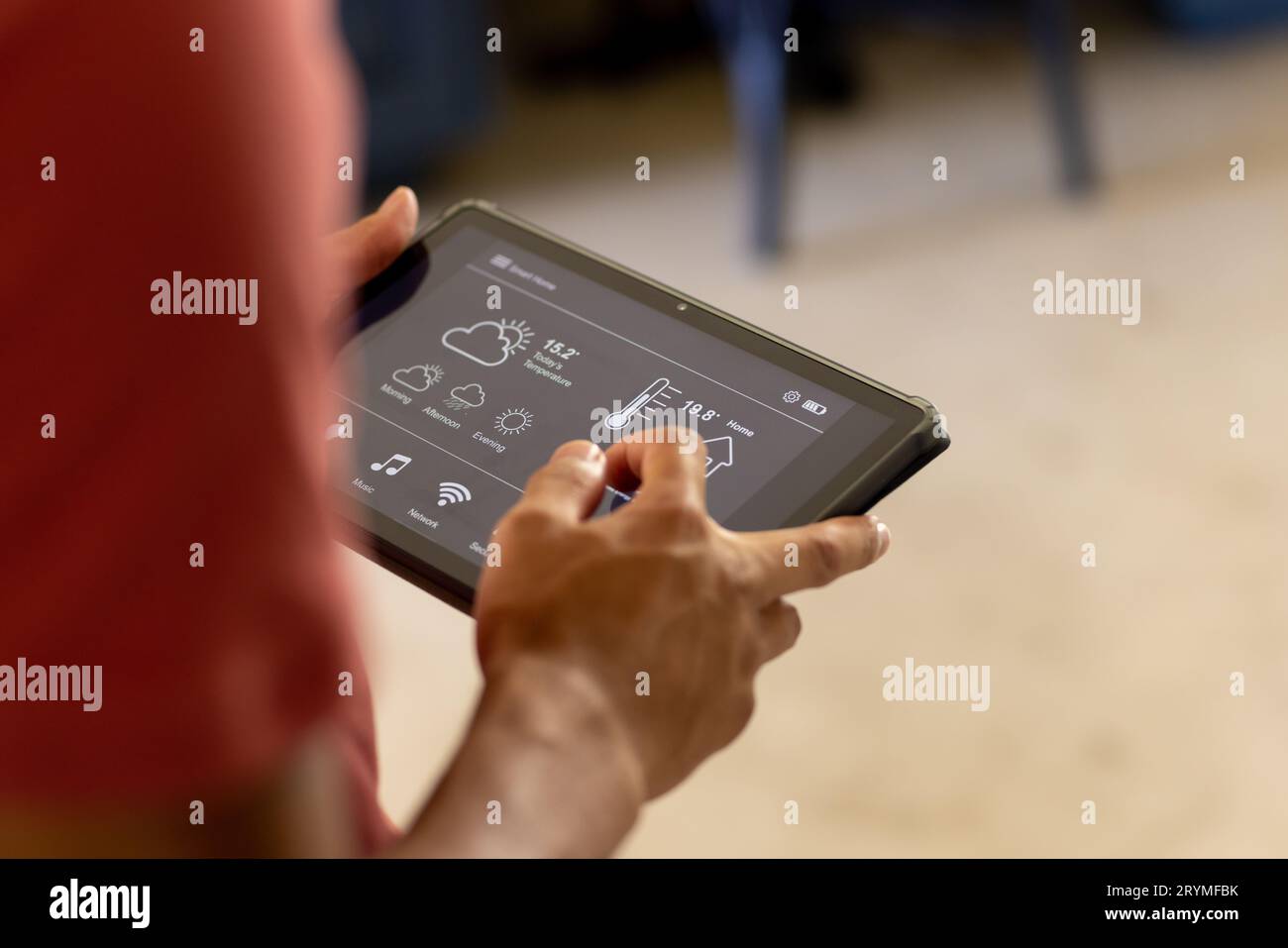 Hands of biracial man using tablet with smart home interface on screen Stock Photo