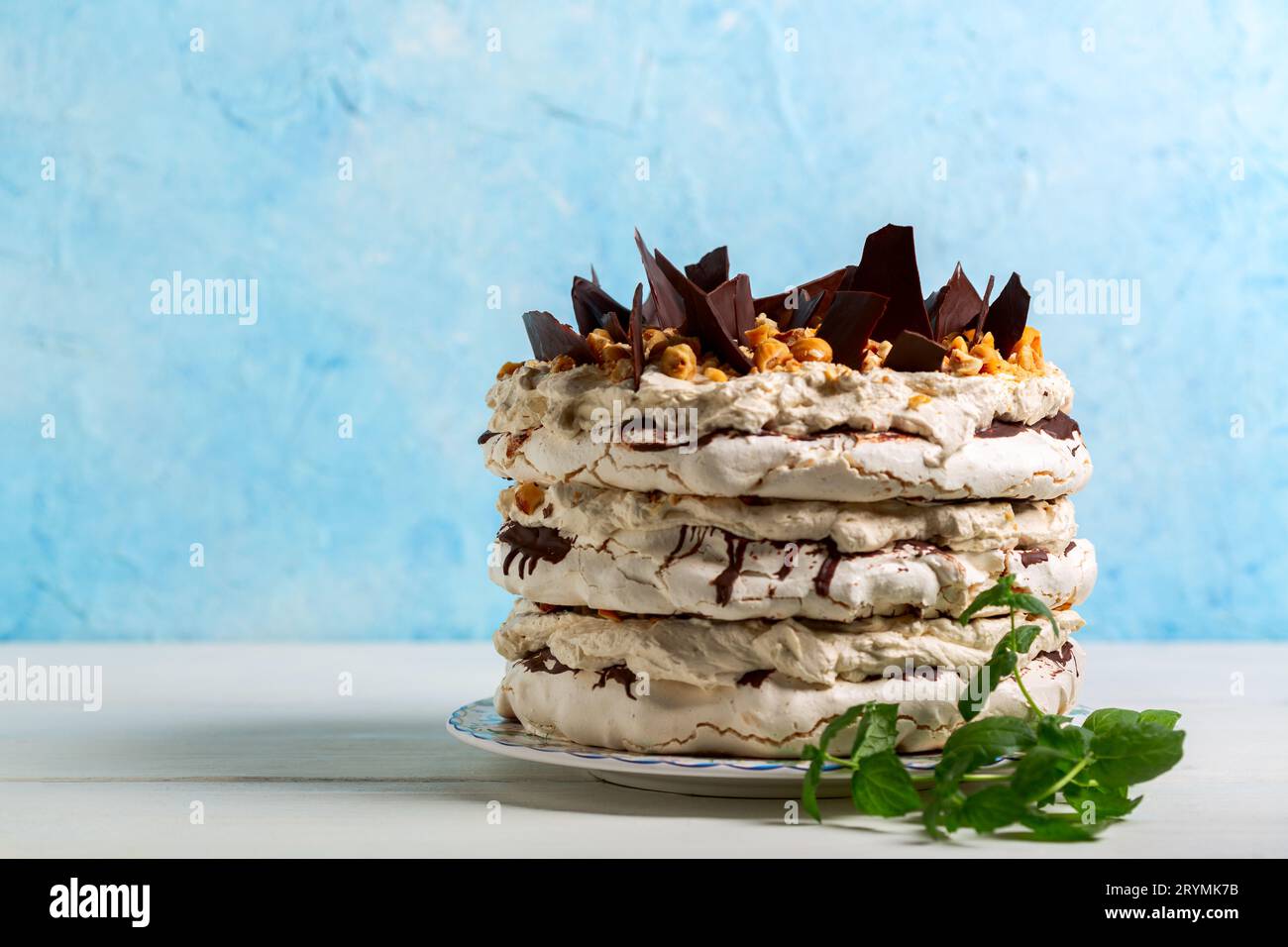 Meringue cake with butter cream, hazelnuts and chocolate. Stock Photo
