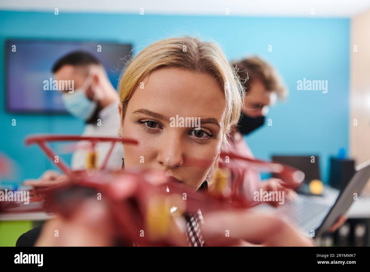 A group of students working together in a laboratory, dedicated to exploring the aerodynamic capabilities of a drone Stock Photo