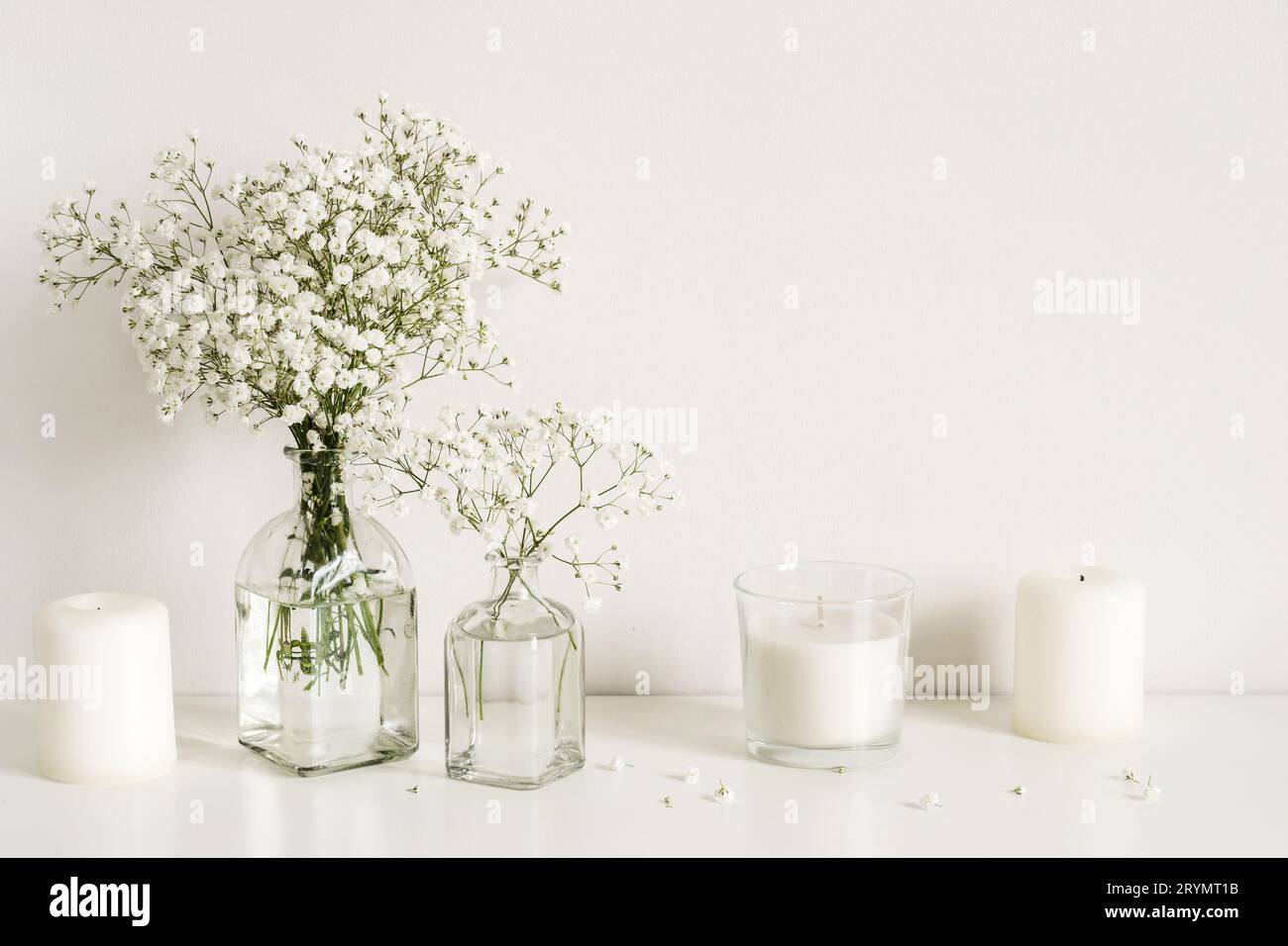 White arrangement of baby's breath flowers and candles. Copy space for lettering Stock Photo