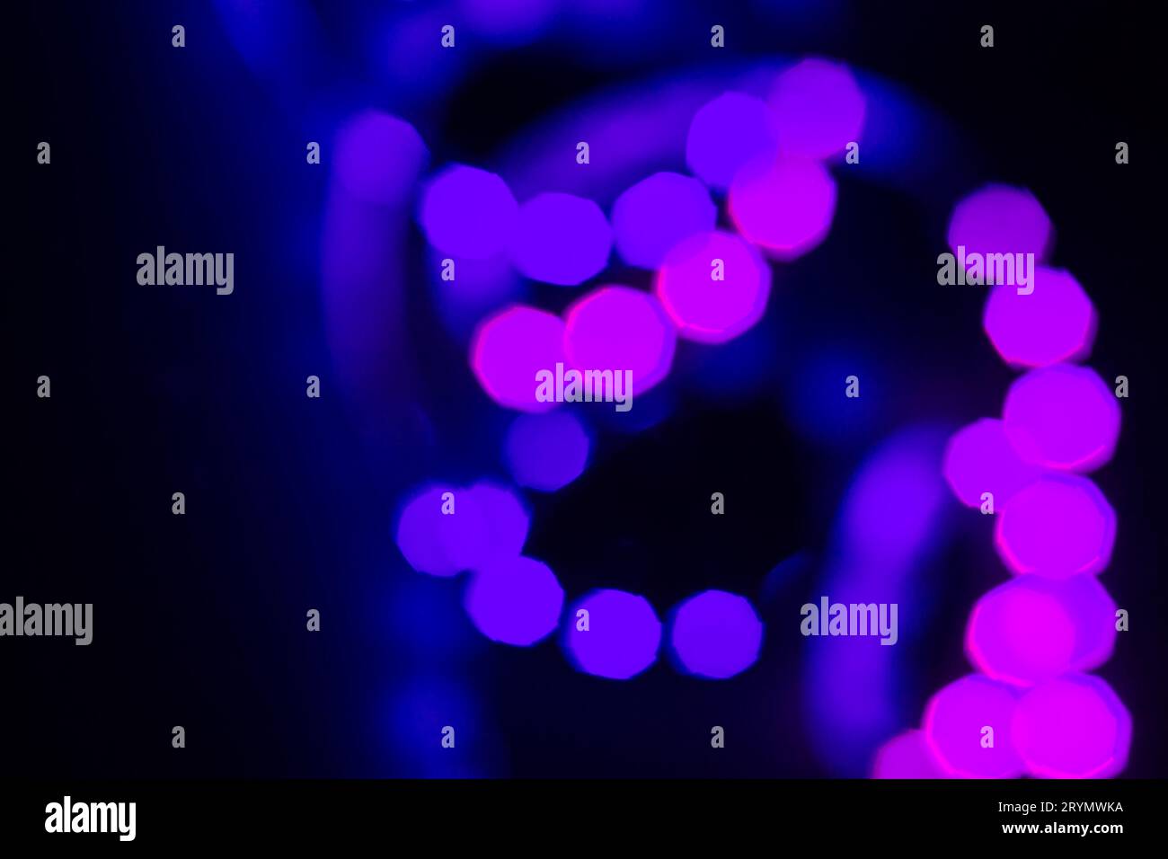 Violet purple neon bokeh lights spiral on black. Abstract background for your design Stock Photo