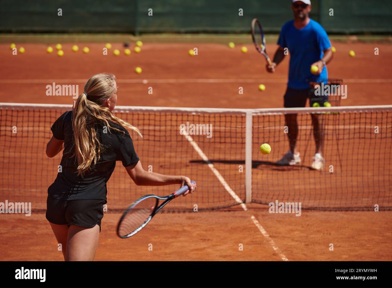 A professional tennis player and her coach training on a sunny day at